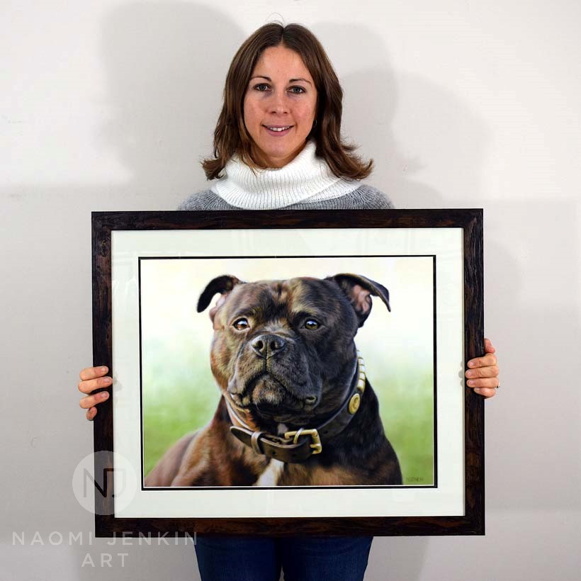 Naomi with the framed pet portrait of Eric the Staffy Dog portrait artist Naomi Jenkin with framed Staffy portrait