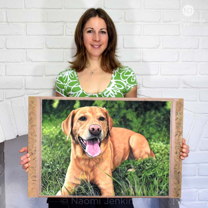 Dog portrait artist Naomi Jenkin with her portrait of Mylo the fox red Labrador